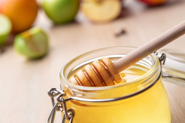 Jüdischer Feiertag Rosh Hashanah mit Honig und Äpfeln auf Holztisch.