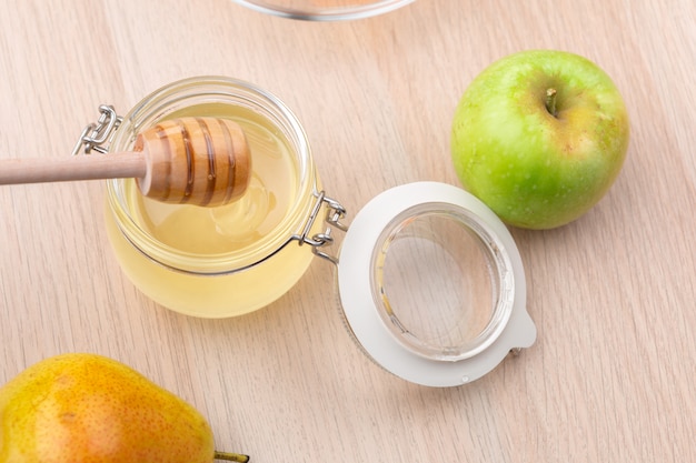 Jüdischer Feiertag Rosh Hashanah mit Honig und Äpfeln auf Holztisch.