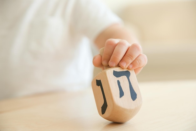 Jüdischer Junge, der zu Hause mit Dreidel spielt