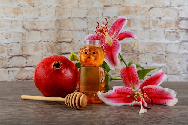 Jüdisches Feiertagssymbol rosa Lilie reife frische Granatäpfel mit jüdischem Symbol des Honigfeiertags