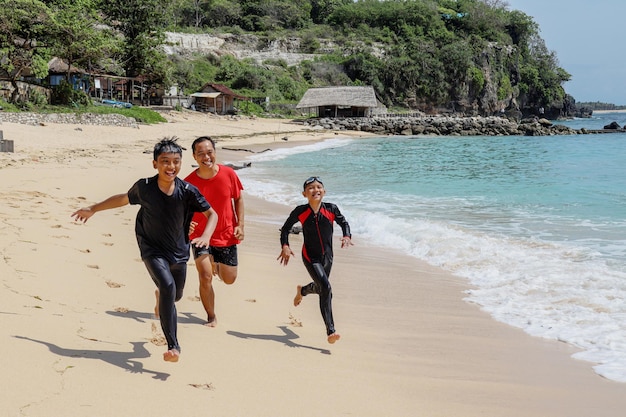 Juega con la familia La felicidad de la familia corriendo en la playa de vacaciones con la familia.