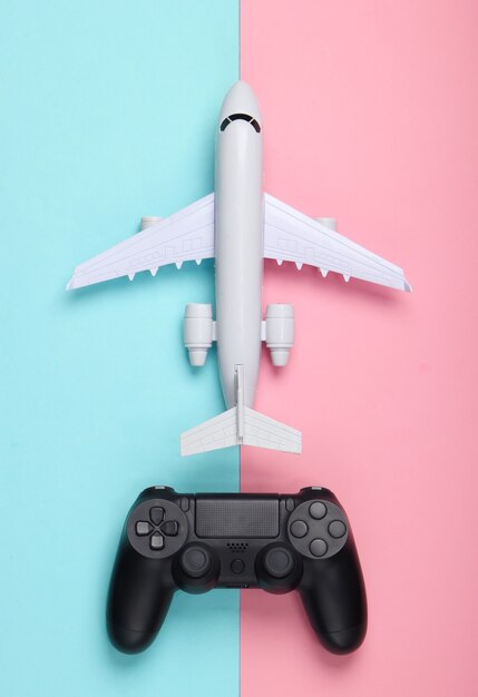 Juego aéreo. Gamepad, avión en un pastel azul-rosa