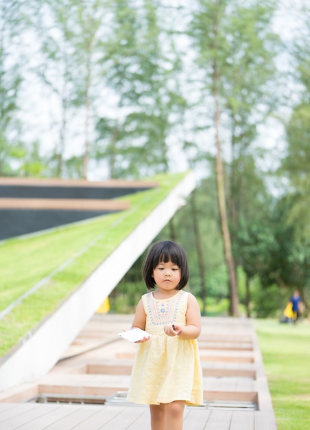 Foto juego asiático de la pequeña muchacha en el parque solamente