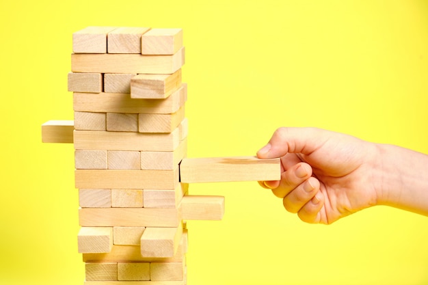 Foto juego de bloques de madera sobre un fondo amarillo.