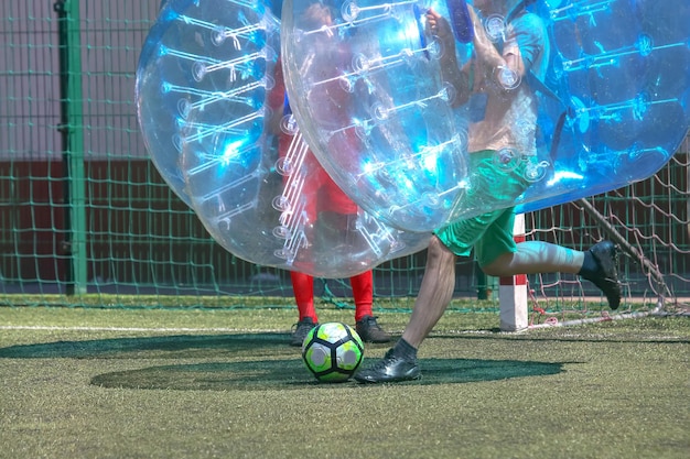 Juego en el campo en globos transparentes juego de pelota de fútbol en esferas transparentes inflables deportes y entretenimiento recreación activa y pasatiempos