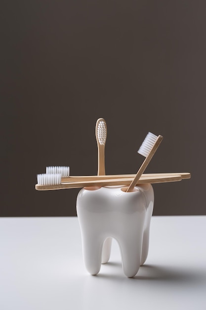 Un juego de cepillos de dientes de madera de bambú ecológicos en un soporte con forma de diente