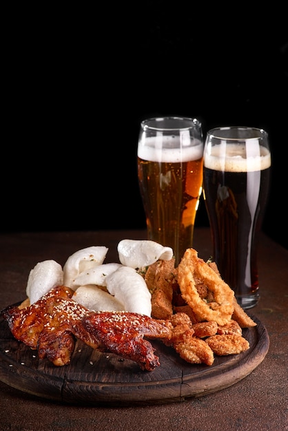 Juego de cerveza. Chip de gambas, calamares fritos, pan de ajo, palitos de queso. Dos vasos de cerveza