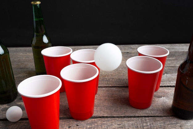 Juego de cerveza Pong en mesa de madera.