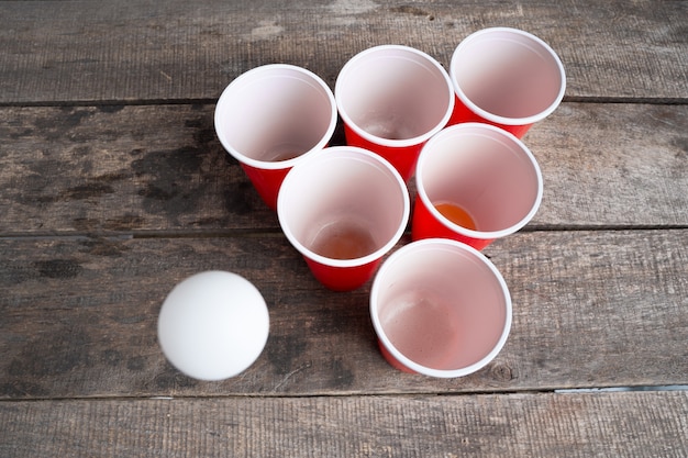 Juego de cerveza Pong en mesa de madera.