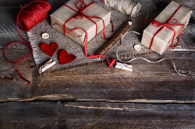 Juego de costura: telas, hilos, alfileres, botones, cinta y corazones hechos a mano sobre arpillera, tela de saco