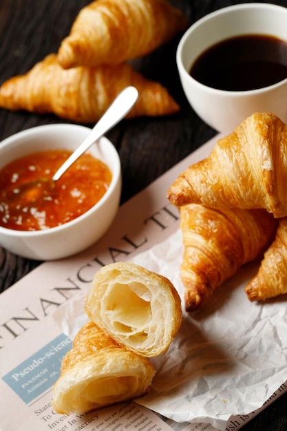 Juego de croissants recién horneados de deliciosos platos de papel encerado en una mesa oscura de madera Vista superior del desayuno francés Espacio de copia