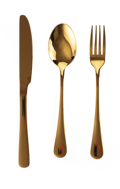 Juego de cubiertos dorados. Tenedor, cuchara y cuchillo aislado sobre fondo blanco.