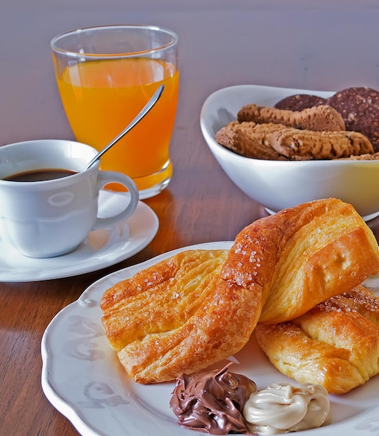 Juego de desayuno con bocadillos, jugo de fruta, galletas, café y té.