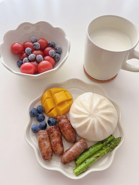 Un juego de desayuno con fruta y leche en un tazón blanco.