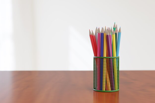 Foto juego de lápices de colores en una canasta sobre una mesa de madera y una pared blanca.