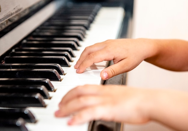 Juego de manos infantiles de educación musical en el piano