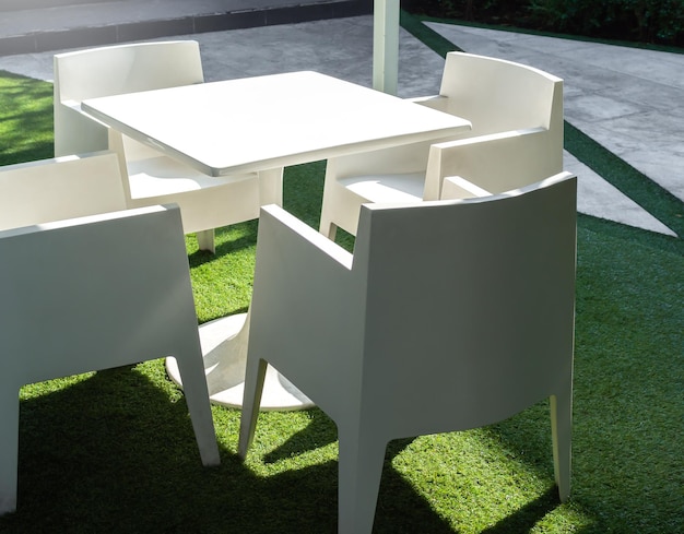 Juego de mesa de comedor al aire libre moderno blanco en patio verde