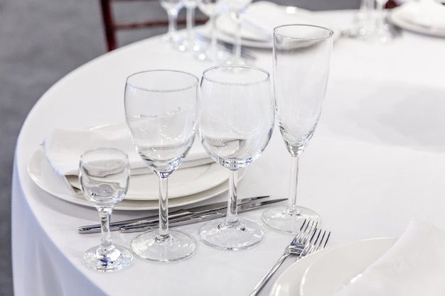 Juego de mesa elegante para cenar con vasos de servilleta en el fondo interior de lujo del restaurante