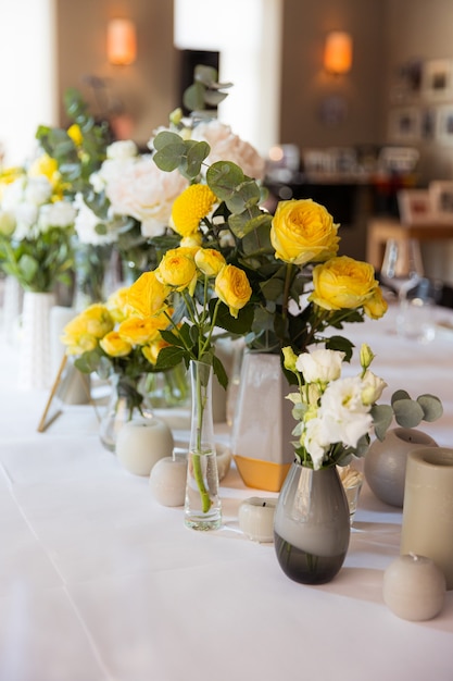 Juego de mesa con rosas amarillas para una fiesta festiva.