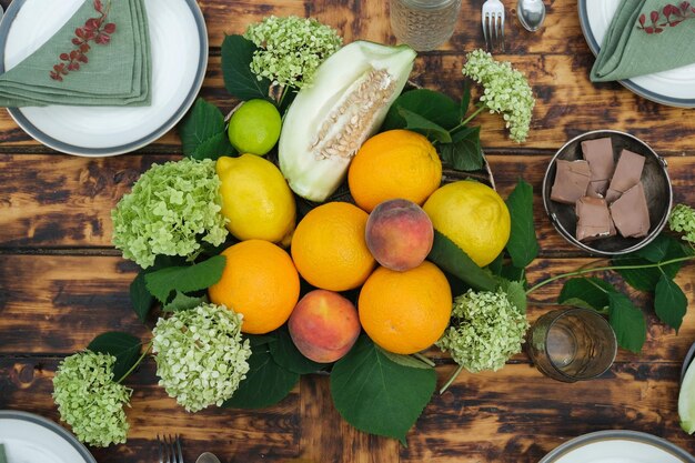 Juego de mesa de verano Mesa de comedor de madera decorada con flores y frutas frescas Vista superior