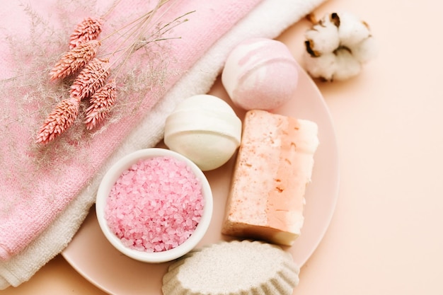 Juego de mimos para el baño Cuidado de la belleza y ocio de relajación Productos cosméticos variados sobre fondo rosa coral