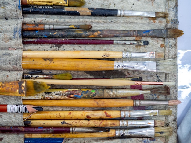 Juego de pinceles de pintura para artistas Plano de muchas herramientas de artista en soporte para pinceles de pintura calico
