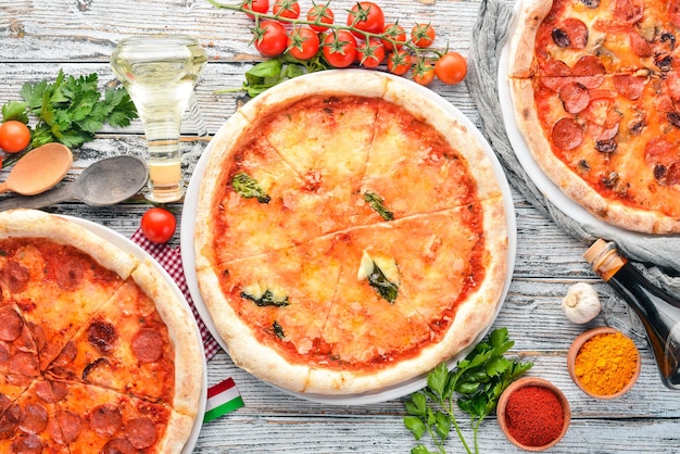Un juego de pizza italiana Cocina italiana Sobre un fondo de madera blanca Espacio de copia libre Vista superior
