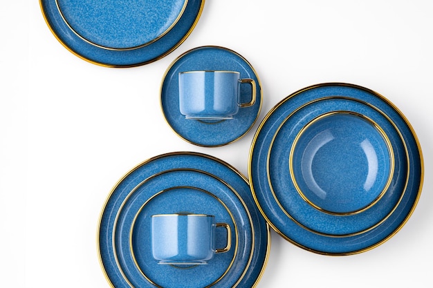 Un juego de platos y tazas de cerámica azul sobre un fondo blanco Vista superior