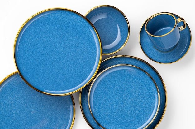 Un juego de platos y tazas de cerámica azul sobre un fondo blanco Vista superior