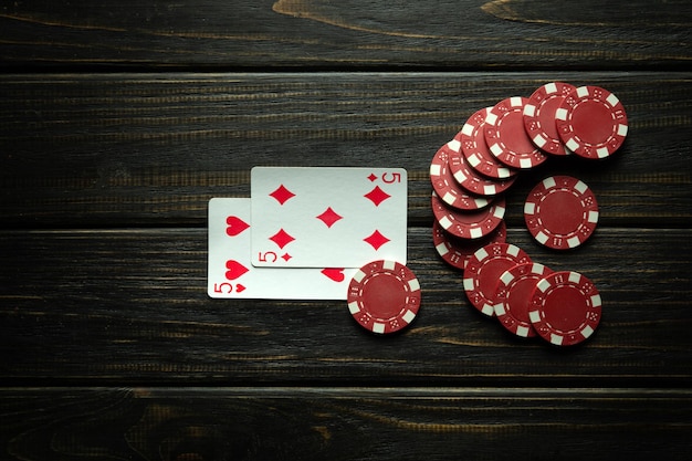 Juego de póquer con una combinación de pares fichas y cartas en una mesa vintage negra en un club de póquer espacio negro gratuito para anuncios