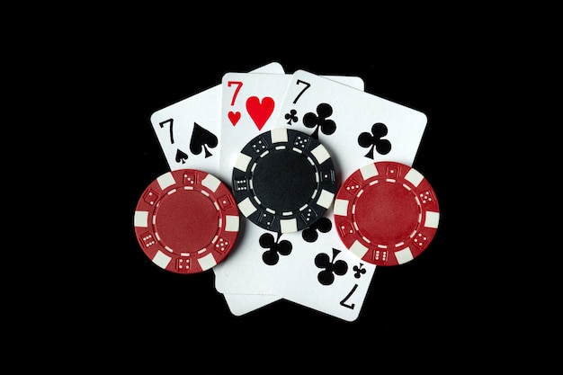 Juego de póquer con tres de una clase o una combinación de fichas y cartas en la mesa negra en el club de póquer