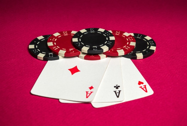 Juego de póquer con tres de un tipo o combinación de fichas y cartas en la mesa roja