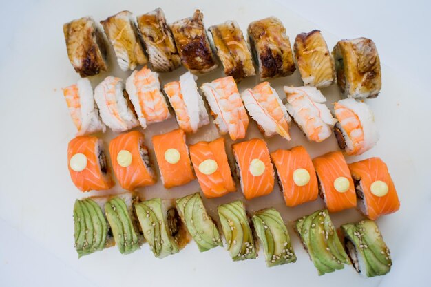 Un juego de rollos de sushi con aguacate, gambas, salmón y anguila.