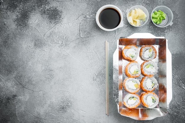 Juego de rollos de sushi en caja de comida de entrega, en piedra gris