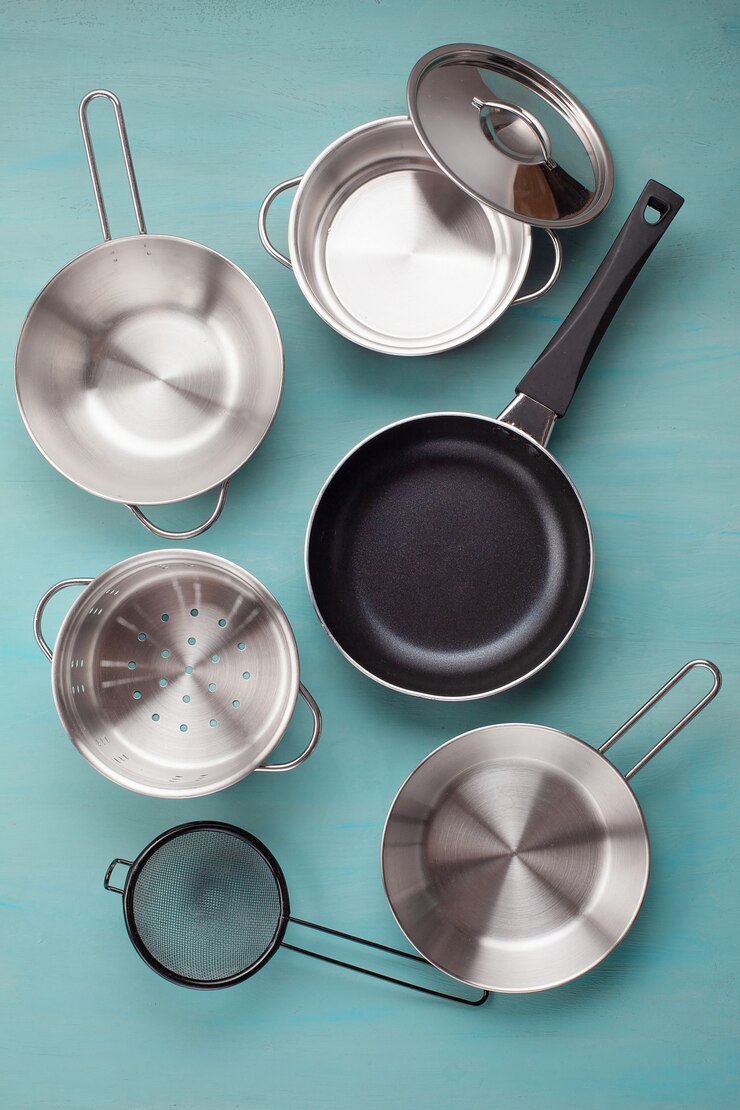 Juego de sartenes metálicos de cocina. Concepto de maqueta, utensilios de cocina, libro de recetas y clases de cocina.