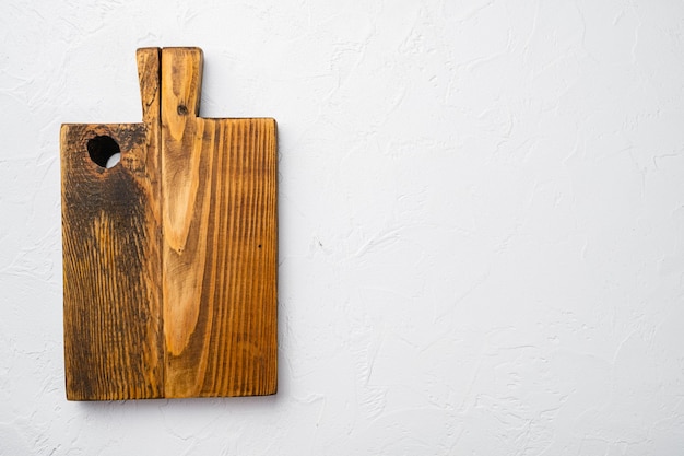 Juego de tablas de cortar de madera envejecida, vista superior plana, con espacio de copia para texto o comida, sobre fondo de mesa de piedra blanca