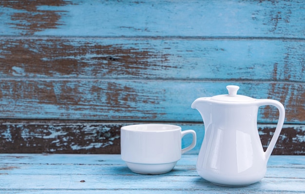 Juego de tazas de té blancas sobre un piso de madera azul