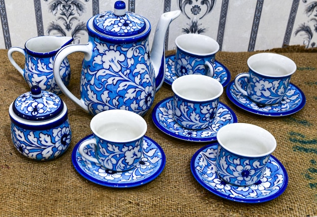 Un juego de té azul y blanco con una tetera y tazas.