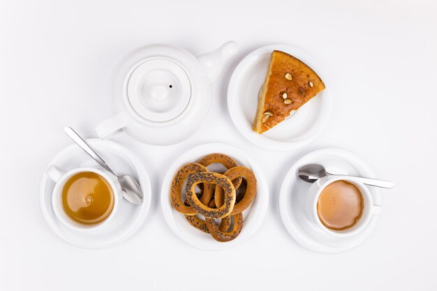 Juego de té blanco con té de tetera y platillos y pastel para el desayuno