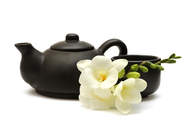 Juego de té chino con tetera, taza y flores blancas