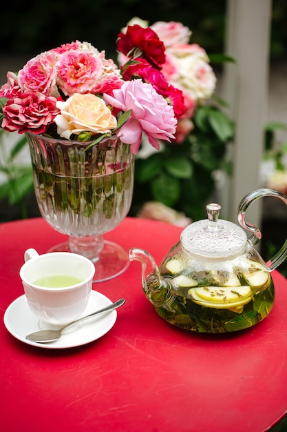 Juego de té en el jardín en la mesa decorada con flores.