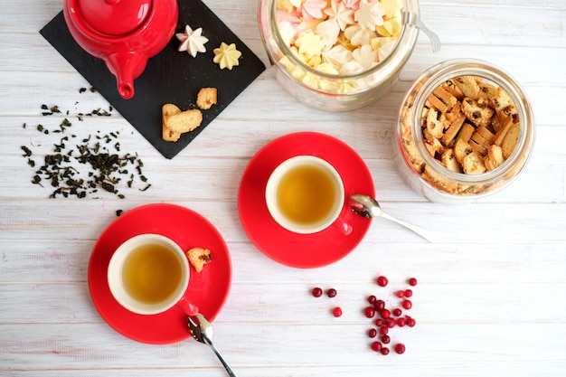 Juego de té en una taza roja y dulce vista superior