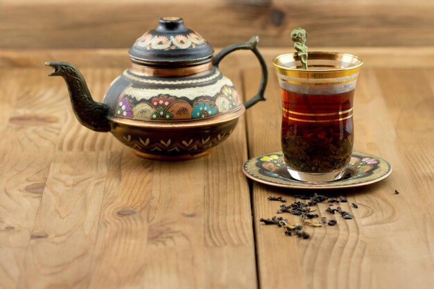 Juego de té turco de una taza de vidrio con una tetera sobre la mesa