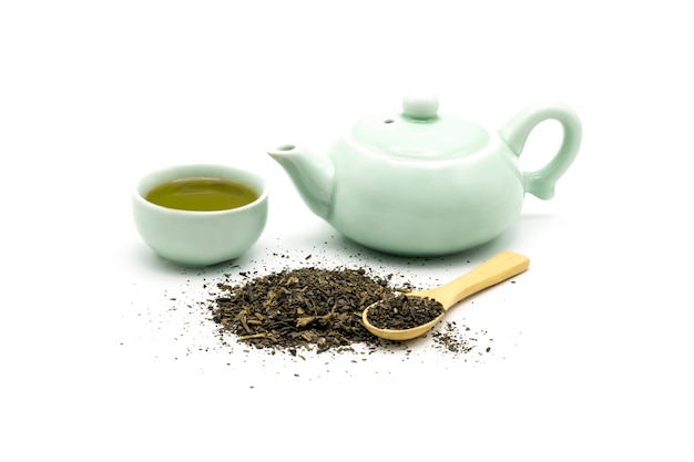 Juego de té verde con hojas verdes secas y cuchara de madera aislado en blanco