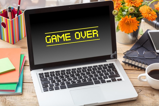 Juego terminado en la pantalla de una computadora portátil en un escritorio de oficina