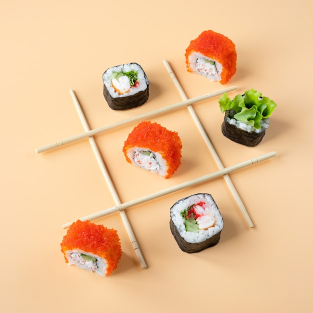 Juego de tic tac toe con sushi sobre fondo naranja