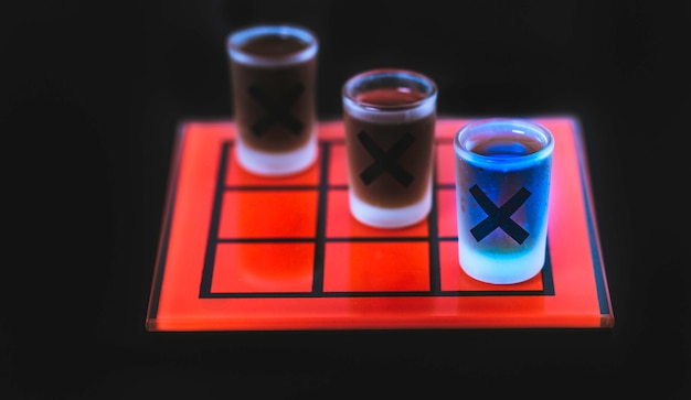 Foto juego de tic tac toe con vasos de chupito.