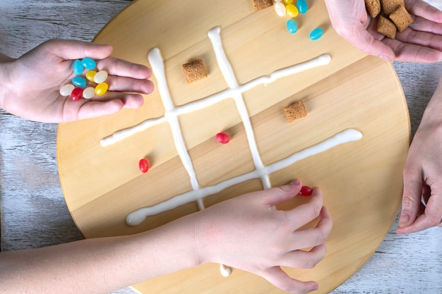 Juego de tres en raya con cereales para el desayuno y dulces coloridos