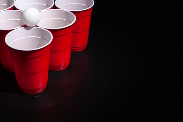 Juego universitario de Beer pong sobre fondo negro