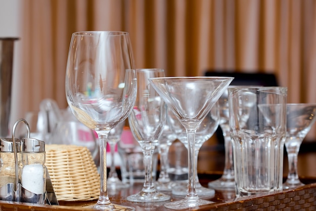 Juego de vasos vacíos de diferentes tamaños en la mesa en el interior. Foto de alta calidad